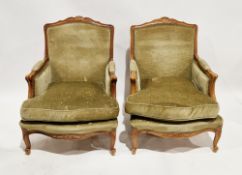 Pair of French walnut framed armchairs in the Louis XV manner, with carved scrolling arms and