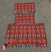 Three matched red ground backed rugs with hooked lozenge pattern 122cm X 75cm, 68cm x 42cm and