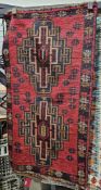 Baluchi red ground rug with tow large geometric medallions, single geometric border  138cm x 74cm