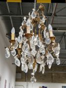 Early 20th century brass and cut glass six branch chandelier in the Louis XV style, the open