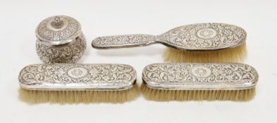 White metal-backed three brush dressing table set and matching lidded dressing pot, possibly Anglo-