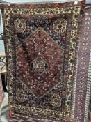 Persian red ground rug with single central lozenge medallion on geometric and floral field,