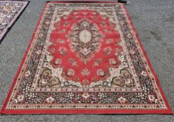 Large European red ground rug with central floral motif, floral spandrels and multiple floral