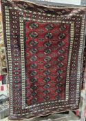 Large red ground Bokhara rug with three rows eleven elephant foot guls on geometric shape field,