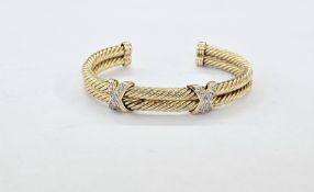 14K gold and diamond bangle of double ropetwist pattern, having two diamond set crosses each set