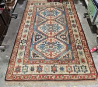 Large blue ground wool pile rug with octagonal geometric medallions enclosed by geometric hooked