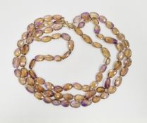 Ametrine three-strand faceted oval bead necklace, strung knotted with yellow metal hook fastening,