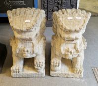 Pair of composite stone garden ornaments in the form of seated Chinese guardian lions or Dogs of Fo,