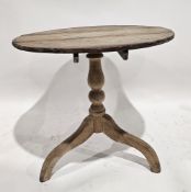George III pine supper table, the circular tilt top on a turned baluster column and three outswept