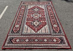 Large red ground rug with three hooked lozenge medallions, floral field and spandrels, multiple