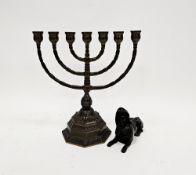 Patinated brass model of an Egyptian sphinx, 12.5cm long and a brass Menorah candle holder on a