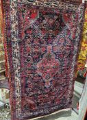 Iranian blue ground rug with central geometric hooked medallion on floral field, hooked spandrels,