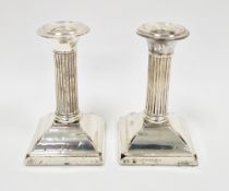 Pair of early 20th century silver squat candlesticks with column stem on square base, assay mark