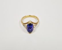 Yellow metal lady's dress ring set with a central blue stone flanked by white stones on either