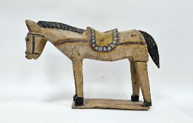 Folk Art hand carved and painted model of a horse or donkey, wearing a saddle, on a plank base, 28cm