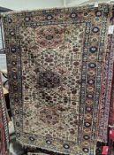 Persian-style cream ground rug with one row of three elephant foot guls and lozenges on floral