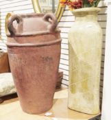 Two large ceramic floor standing vases one red painted with four loop handles, the other with