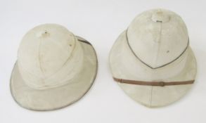 Two pith helmets in fitted metal hat box, the box is named to 