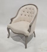 Modern French-style armchair, with a distressed wooden frame and button back cream upholstery, on