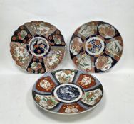 Three Japanese porcelain imari-pattern Meiji period chargers, the first of fluted form painted
