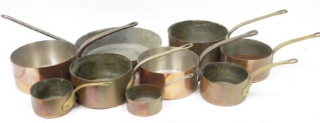 Set of five copper saucepans with brass handles, graduating in size from 12 to 16 together with