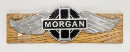 Large aluminium Morgan wings car badge, 45cm long, mounted on an oak plinth