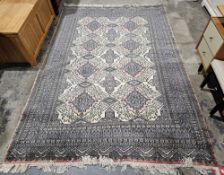 Large apricot ground rug with two rows of four hooked lozenge medallions, on geometric field,