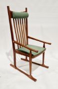 Modern teak elbow chair with slatted back and upholstered seat and decorative visible joints, a