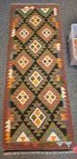 Maimana green ground kilim runner with two rows of three and one row of four lozenge medallions,