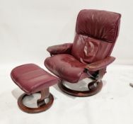 Ekornes Stressless easy chair with matching stool, both upholstered in maroon leather, on a