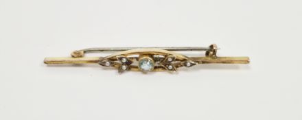 Edwardian gold bar brooch set with a central circular aquamarine flanked by leaf detail set with