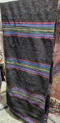 Large black ground runner with multiple rows of red yellow blue stripes 382cm x 88cm