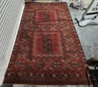 Large red ground carpet with two large central square medallions on field of elephant foot guls,