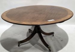 Mahogany dining table in the Regency manner, the circular cross-banded tilt top on turned tapered