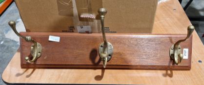 Three wooden-mounted Victorian brass coat hooks, of differing design, one with gadrooned knop and