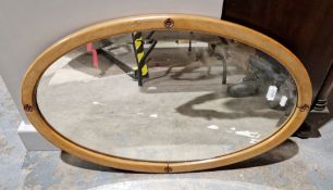Contemporary oval wooden-framed wall mirror carved with foliate roundels, 73cm high