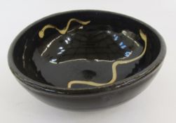 Winchcombe bowl in the style of Michael Cardew, slightly elliptical, dark brown glazed with cream