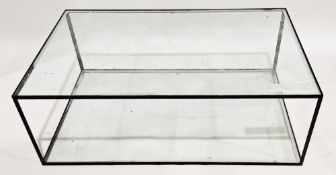 Contemporary coffee table, comprising a clear glass top and undershelf held on a black metal