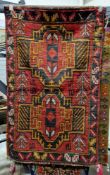 Baluchi red ground rug with two large geometric medallions, single floral border 140cm x 87cm