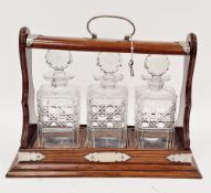 Stained wood tantalus with silver-plated mounts, with three cut glass decanters, with key, 39cm wide