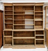 19th century stripped pine library breakfront bookcase, the moulded cornice over a wide open front