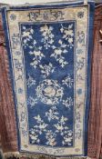 Pair of Chinese blue ground rugs with central floral motif, floral field and single floral border,