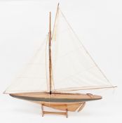 Wooden model yacht with black painted hull and cloth sails, on stand, 102cm high x 105cm long