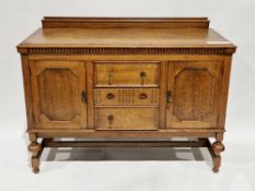 Early 20th century oak sideboard in the Jacobean manner, the top with upstand over an arrangement of