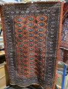 Eastern rust coloured ground rug with three rows of thirteen elephant foot guls and two rows of