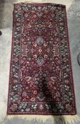 Persian style red ground rug with two floral medallions on floral field, multiple floral borders,