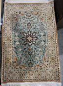 Persian silk green ground rug with central floral motif on woven floral field, floral spandrels