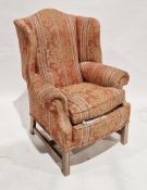 Wingback armchair in the George III style, upholstered in a floral fabric on a pink ground, on