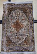 Persian silk cream ground rug with central geometric medallions, floral field and spandrels,