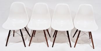 Set of four Eames DSW dining chairs, having white plastic seats, turned wooden legs and chrome-